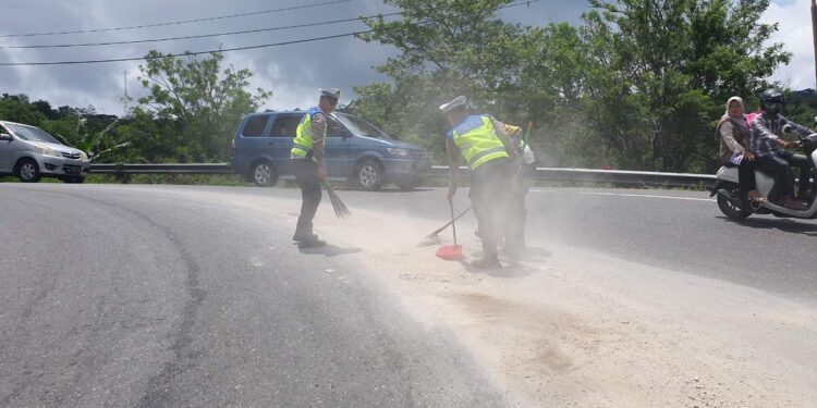 Membahayakan Pengguna Jalan, Satlantas Polres Aceh Tengah Sigap Bersihkan Pasir Yang Berserakan Di Jalan Raya