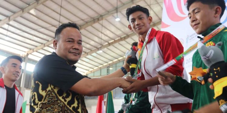 Pj. Sekda Aceh Timur Mengalungkan Medali Emas Cabor Pencak Silat POPDA