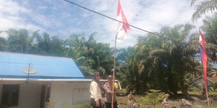 Sambut HUT RI ke-80, Bhabinkamtibmas dan Warga Rantau Baru Pasang Umbul-Umbul Merah Putih