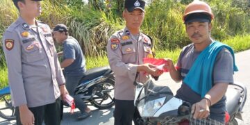 Polsek Kerumutan Bagikan Bendera Merah Putih untuk Sambut HUT RI ke-80