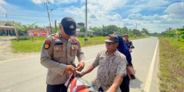 Polsek Teluk Meranti Bagikan dan Pasang Bendera Merah Putih di Desa Pulau Muda