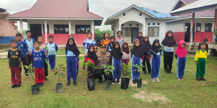 Polisi Tanam Bibit Pohon di SD 016 Pulau Muda Dukung Program Penghijauan Kapolda Riau