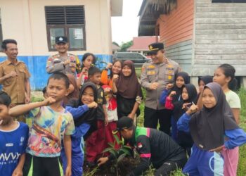Polisi Tanam Bibit Pohon di SD 016 Pulau Muda dalam Program Penghijauan Kapolda Riau