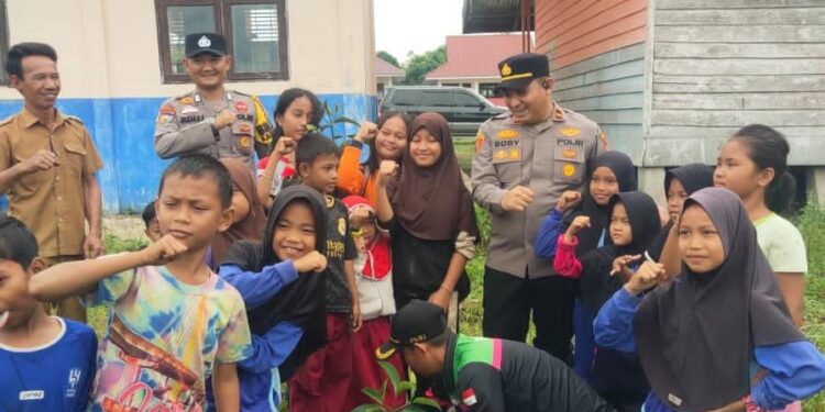Polisi Tanam Bibit Pohon di SD 016 Pulau Muda dalam Program Penghijauan Kapolda Riau